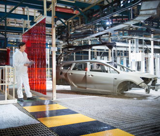 An auto factory worker inspecting car production line.